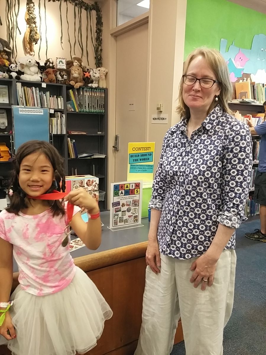 Ari at the library desk with a librarian