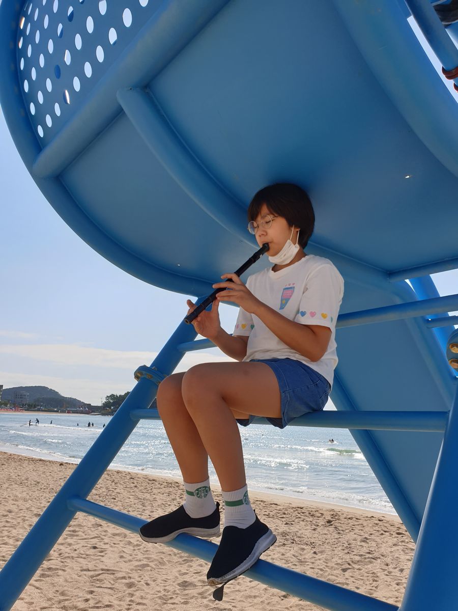 Playing flute on a lifeguard tower at the beach