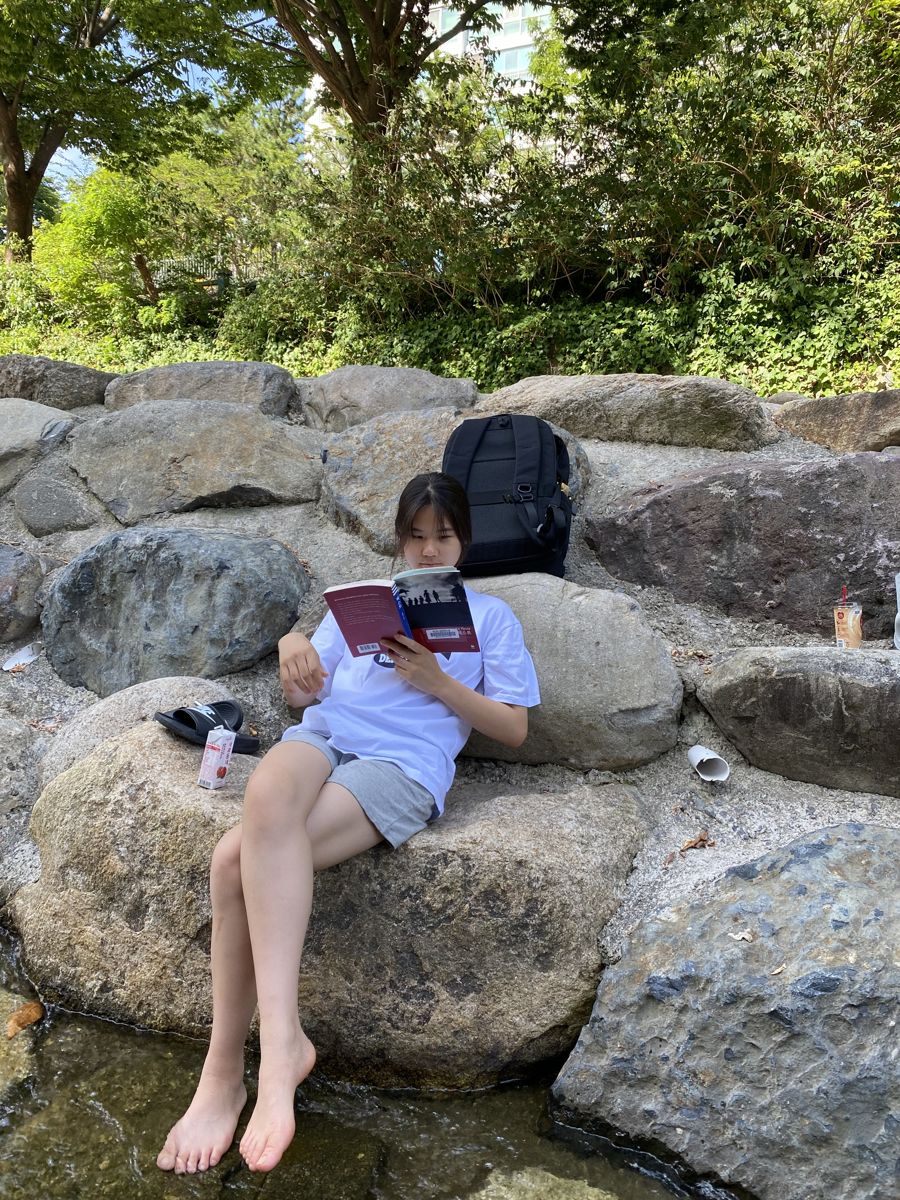 Reading on rocks by a stream
