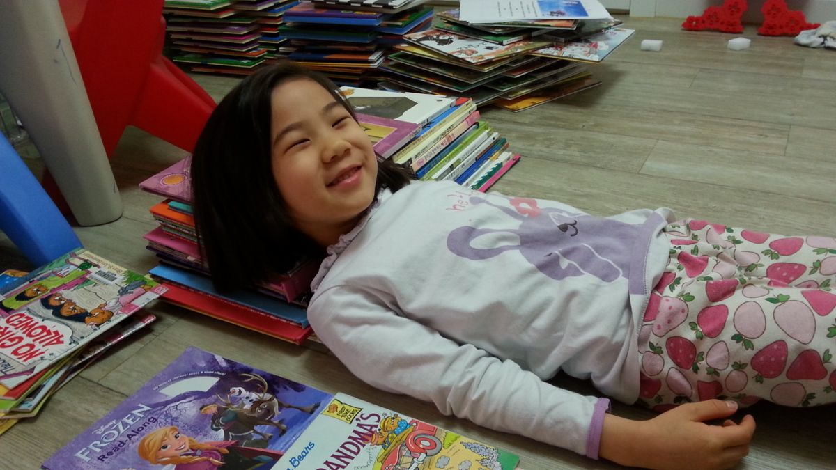 Lying on the floor surrounded by books
