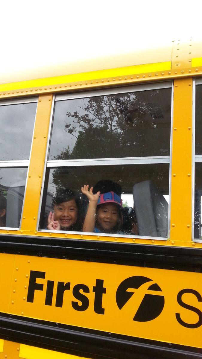 Kids waving from a school bus